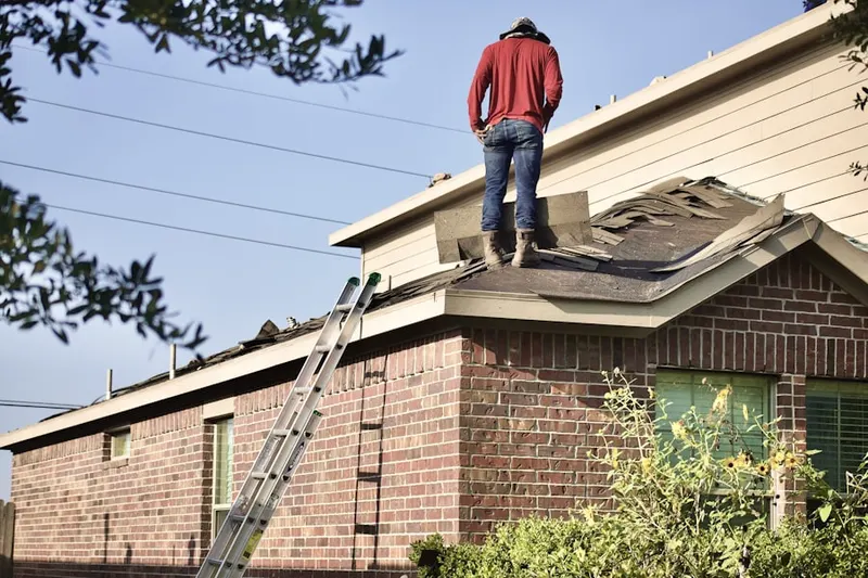 Professional roofer working on a residential roof in Ballouville
